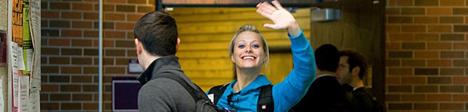 Young blonde woman waving