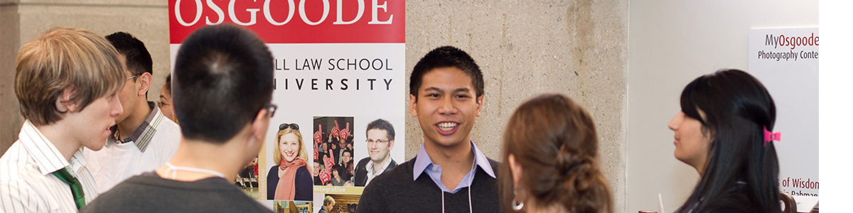 Group of students standing in front of Admission banners