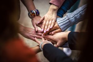 People putting their hands together to form a circle