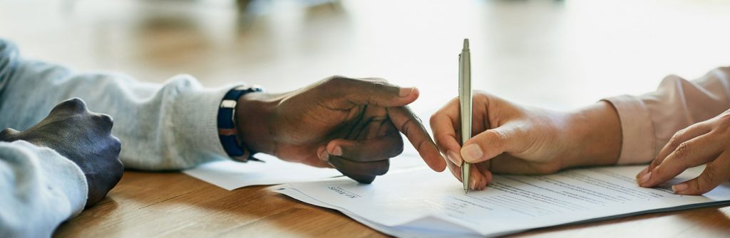 Two hands signing a paper.