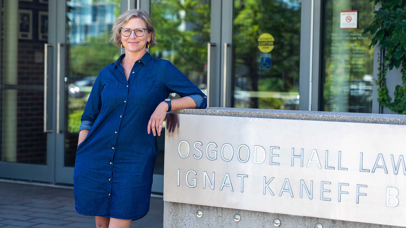 Dayna scott standing at entrance to osgoode hall law school