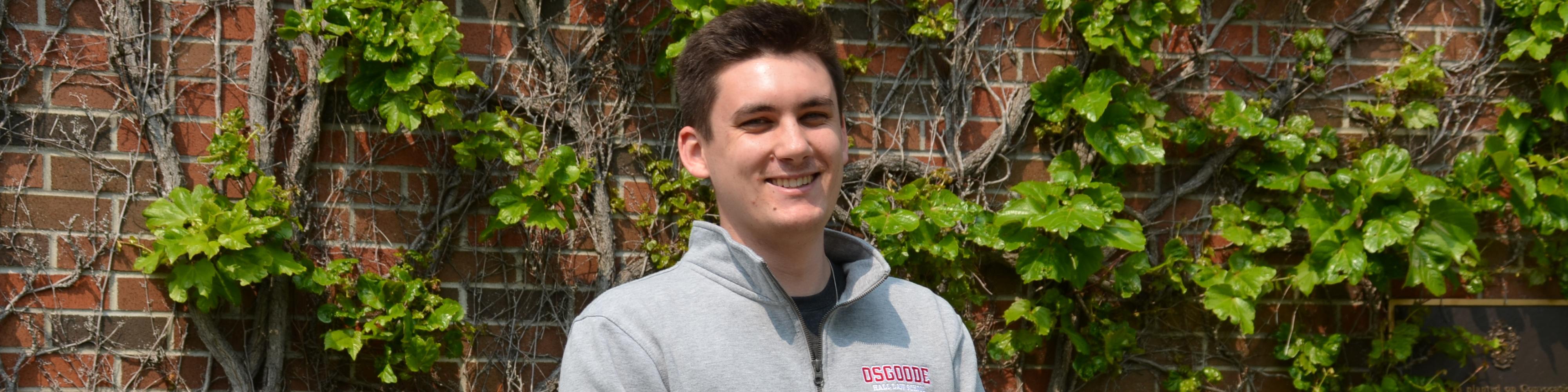 Photo of Justin Thompson outside Osgoode building with ivy in the background