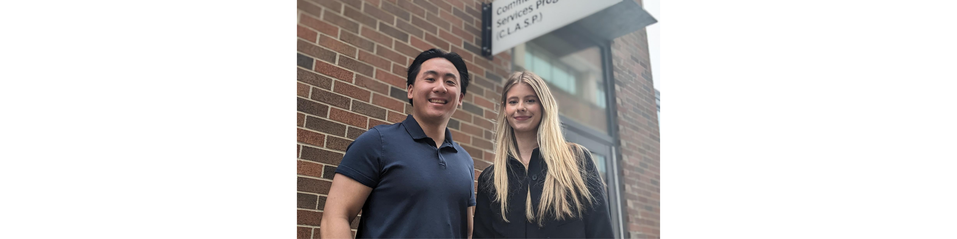 Photo of Osgoode students Brandon Jeffrey Jang (left) and Emma Sandri outside the CLASP office at Osgoode